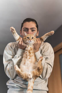 files/young-man-playing-with-cat-at-home-JAQF00199.jpg